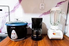 Eine Küche mit einem Slow Cooker, einer Kaffeemaschine und einem Mixer auf einer Holzauskład.