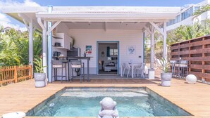 Espaço ao ar livre coberto com piscina, bar e área de estar.
