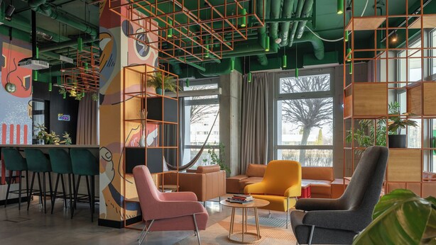 Un interior moderno con una zona de bar, asientos y ventanas amplias.