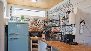 A compact kitchen with a blue Galanz refrigerator, a microwave, a coffee machine, and a sink. - Cozy Cabin w a view & Tesla EV Charger (Dripping Springs)