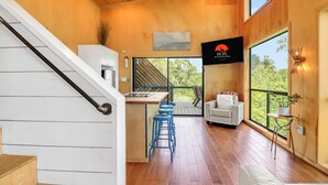 Ein modernes Interieur mit Küche, Essbereich und großen Fenstern.