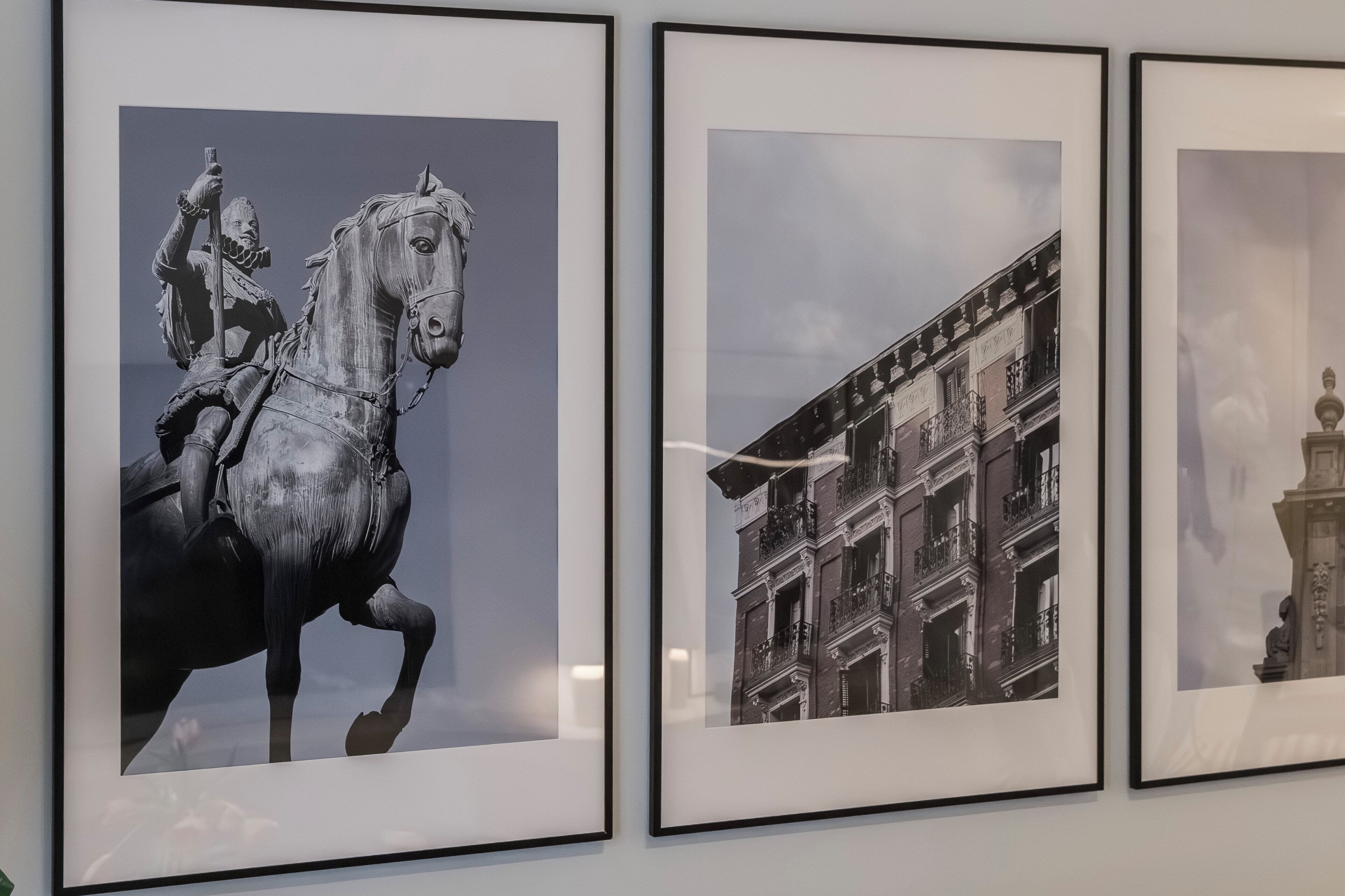 Three framed photographs: a statue of a knight on horseback, a building facade, and a statue on a pedestal.