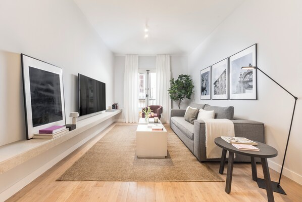 Ein modernes Wohnzimmer mit einer Couch, einem Couchtisch und einem Fernseher.