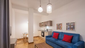 A modern living room with a blue sofa, wooden coffee table, and pendant lights. - U Genova (Genoa)