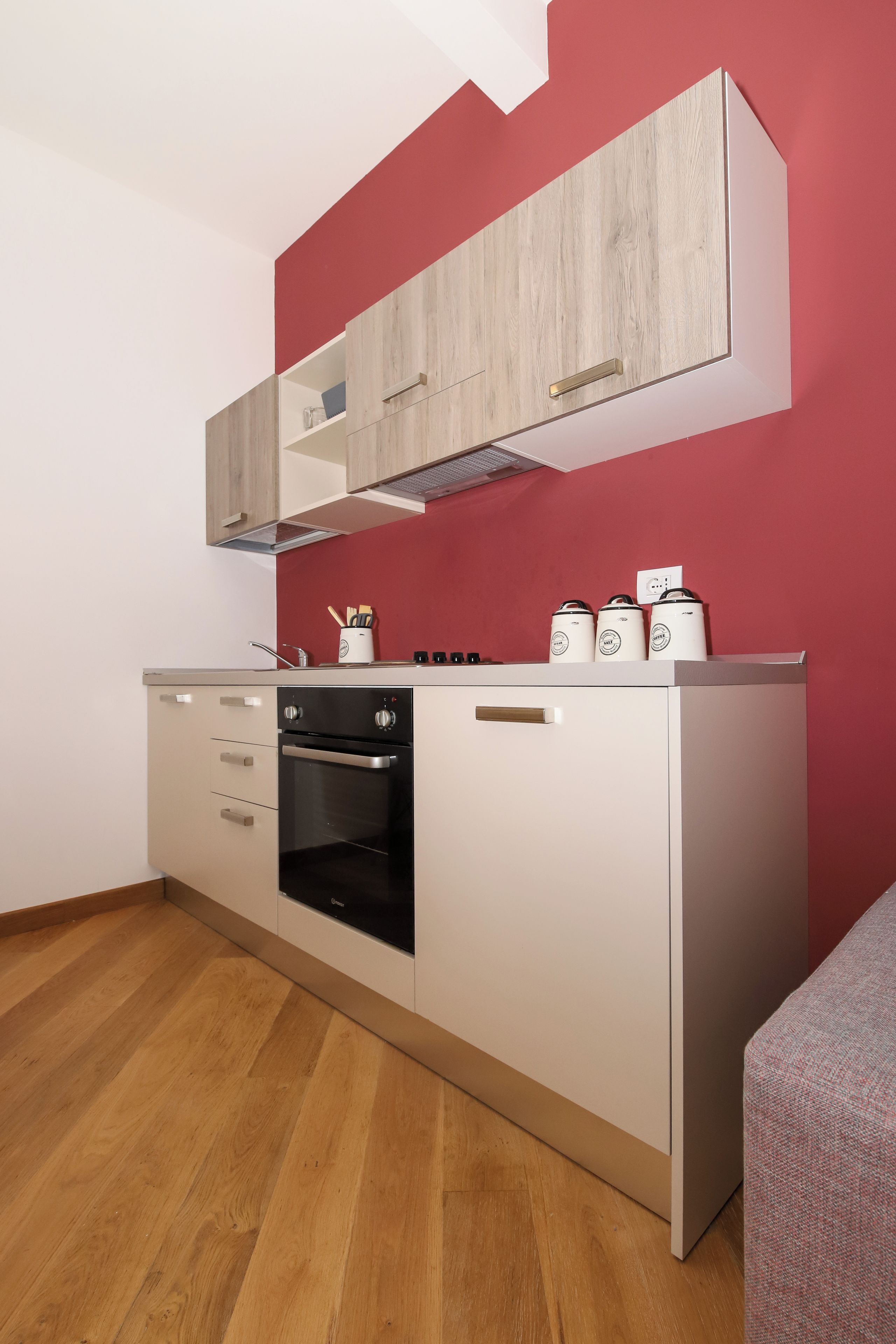 A compact kitchen with a built-in oven, a microwave, and a coffee maker on the countertop.