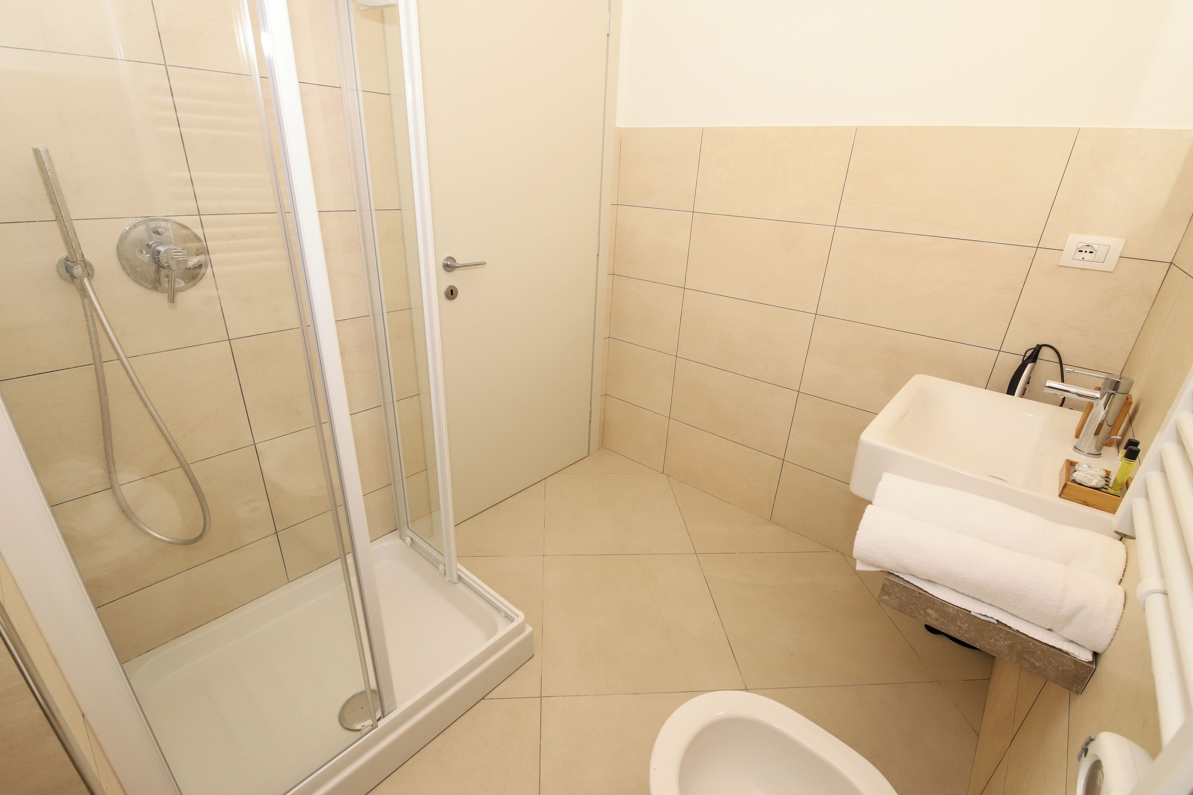 A bathroom with a shower, toilet, and sink.