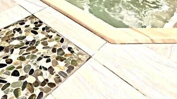 A stone wall surrounding a hot tub area with a mosaic tile floor. - 4301  Hot tub, sauna & more resort amenities  Shepherd's Retreat (Beech Mountain)