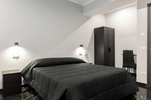 A modern bedroom with a bed, nightstands, a wardrobe, and wall-mounted lighting. - Magami Station Ciampino (Ciampino)