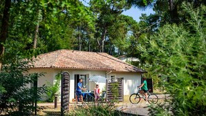 Una casa pequeña con techo de tejas, rodeada de árboles.