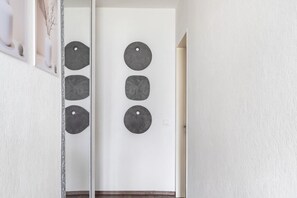 Ein Flur mit einer weißen Tür und einem Spiegel, der die Tür reflektiert.