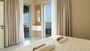 Una camera d'albergo con un letto, un bagno con uno specchio e un balcone con tende.