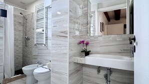 Ein modernes Badezimmer mit Dusche, zwei Waschbecken, Toilette und Spiegel.