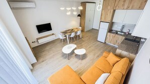 Um apartamento moderno com sala de estar, espaço para refeições e cozinha.