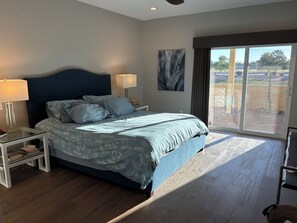 A bedroom with a large bed, two bedside tables, a nightstand, a window with a view, and a ceiling fan. - Charming Old Town Scottsdale with heated pool (Scottsdale)