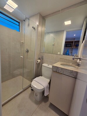 A modern bathroom with a glass-enclosed shower, a toilet, and a sink with a granite countertop. - Mahrak Villa Maracaipe (Ipojuca)