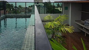 Una piscina sul tetto con vista sull'oceano e palme.