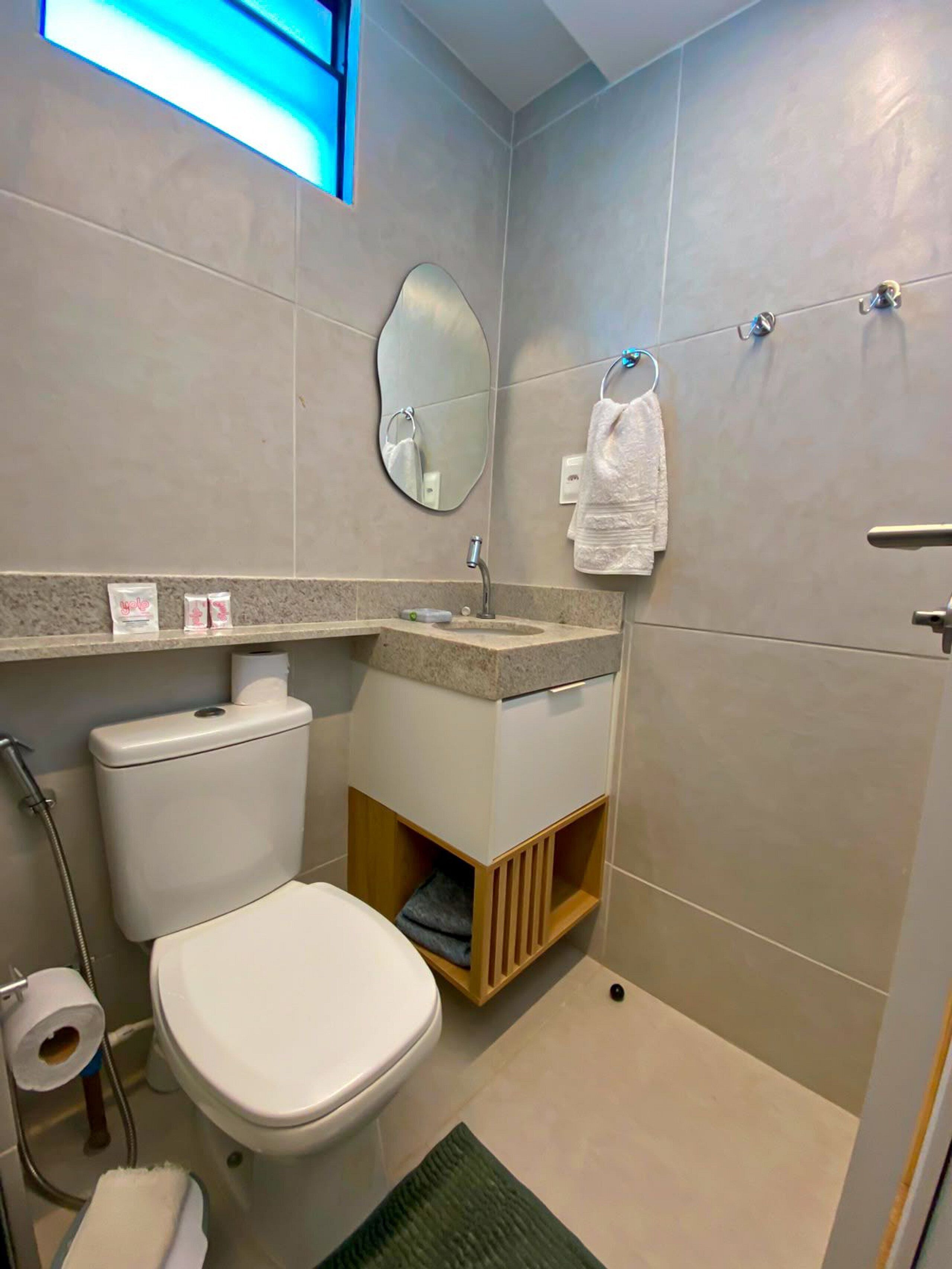 Un bagno piccolo e funzionale, con il water, il lavandino e uno specchio.