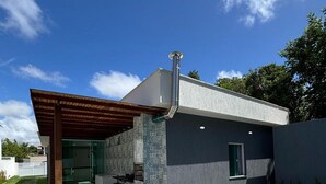 A modern house with a swimming pool, a covered patio, and a tiled exterior. - Casa Parque das Árvores - Camaçari - BA (Camaçari)