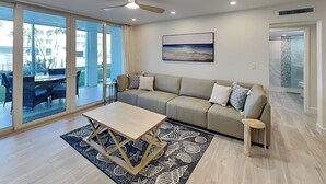 Una sala de estar moderna con un sofá, una mesa de centro y vistas al exterior.