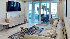 Una sala de estar moderna con sofá, mesa de centro y televisor.
