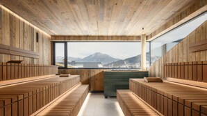 Een houten interieur met zitplaatsen en uitzicht op bergen.
