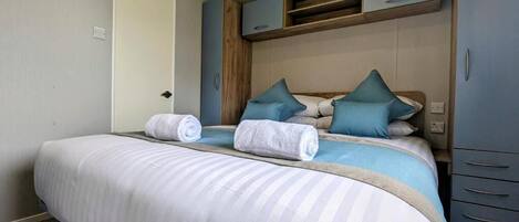 A bedroom with a large bed, a wardrobe, and a door.
