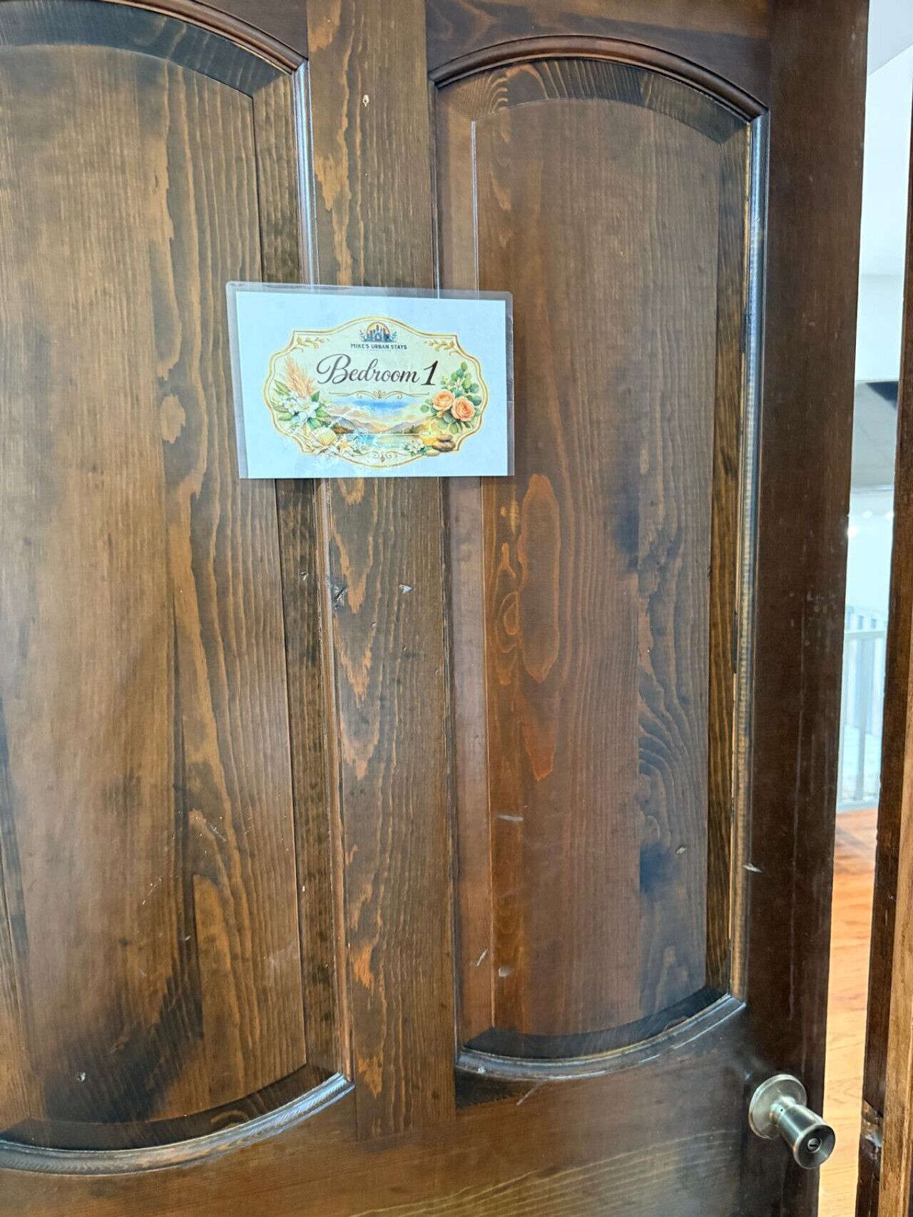 Une porte en bois avec une plaque indiquant « Chambre 1 » et un motif décoratif.
