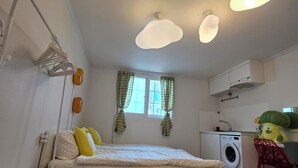 Ein Schlafzimmer mit Bett, Waschmaschine und Küchenzeile.
