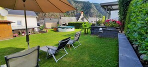 Un jardin avec une piscine, des chaises et une pergola.