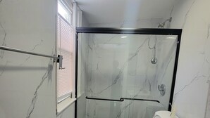 Ein Badezimmer mit Duschkabine, Toilette und Waschbecken.