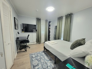 A bedroom with a bed, a desk, a chair, a television, and a window with curtains. - Room in Newark with Parking (Newark)