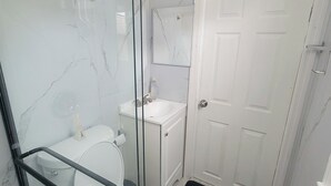 Ein Badezimmer mit Toilette, Waschbecken und Duschbereich.