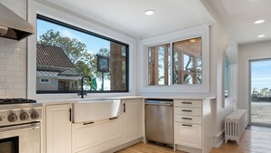 A modern kitchen with white cabinetry, a stainless steel stove, and a dishwasher.