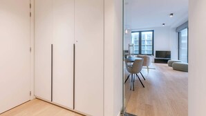 Un soggiorno moderno con zona pranzo, ampie finestre e televisione a schermo piatto.