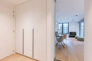 A modern living room with a dining area, large windows, and a flat-screen TV. - Modern apartment in the Iconic Ensor Tower (Oostende)
