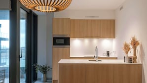 Una cucina moderna con mobili in legno, forno a microonde integrato e isola centrale con lavello.