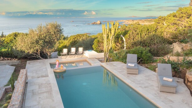 A swimming pool with lounge chairs and a view of the sea. - Calypso Lux Independent Villa (AGLIENTU)