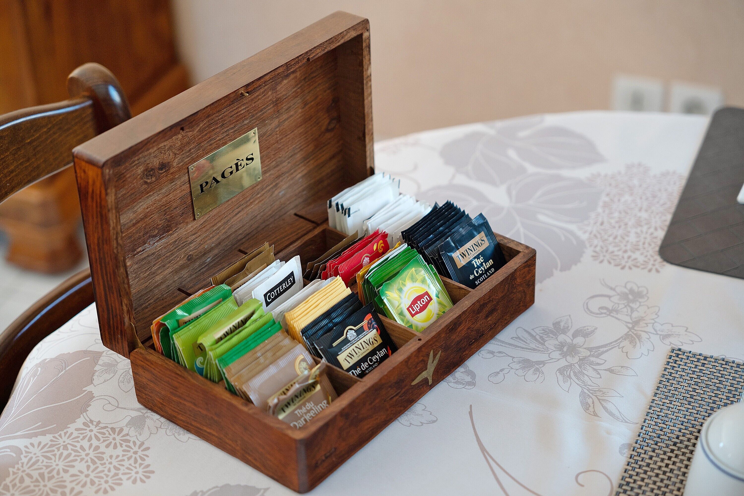 A wooden box with compartments containing various tea bags.