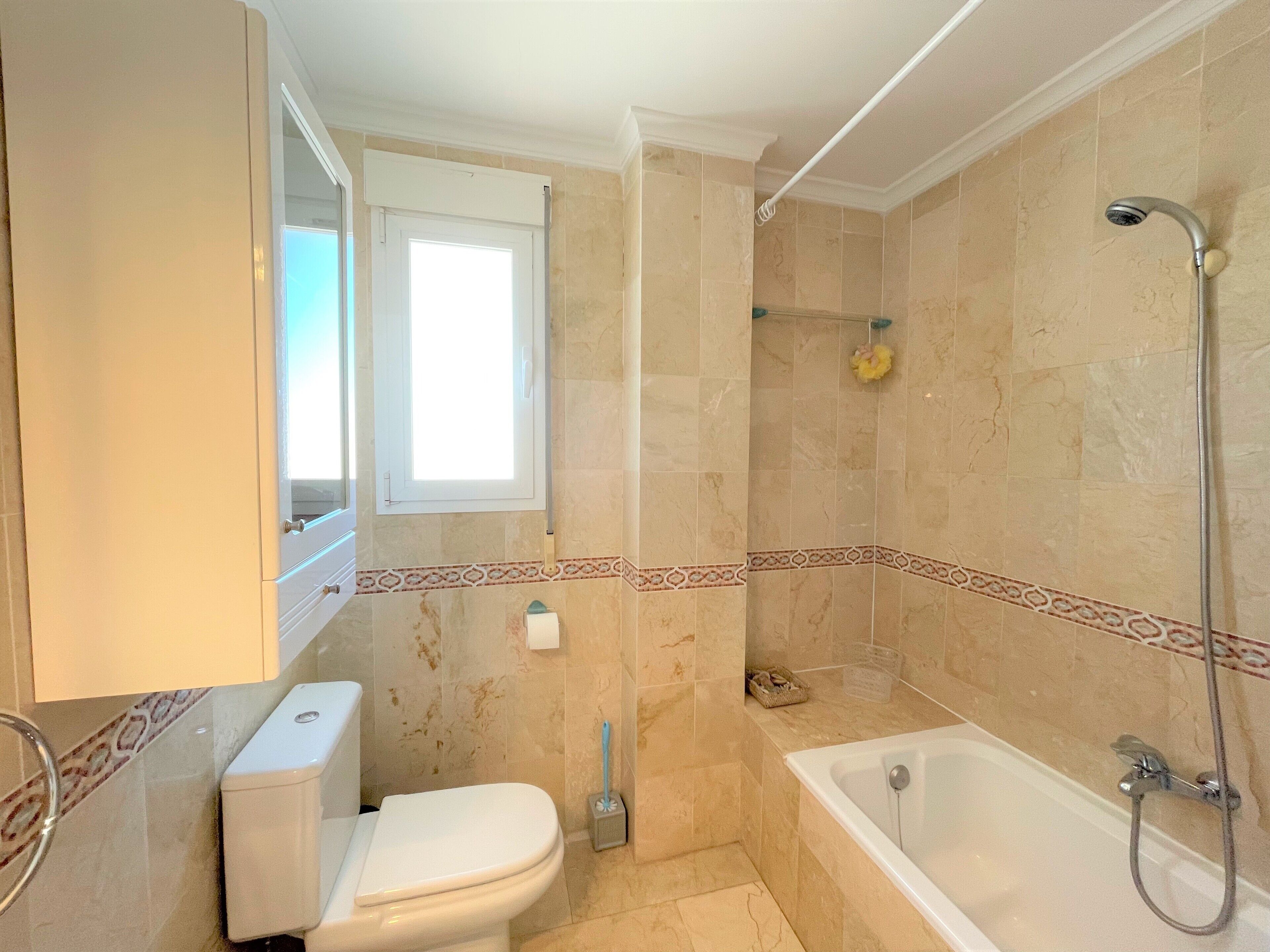 A bathroom with a toilet, a shower, and a bathtub.