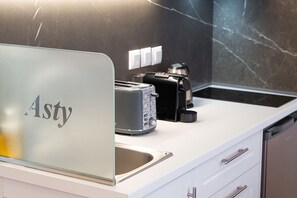 A modern kitchen with a toaster, a coffee maker, and a sink. - Asty Luxury Apartments/Asty 2 (Athens)