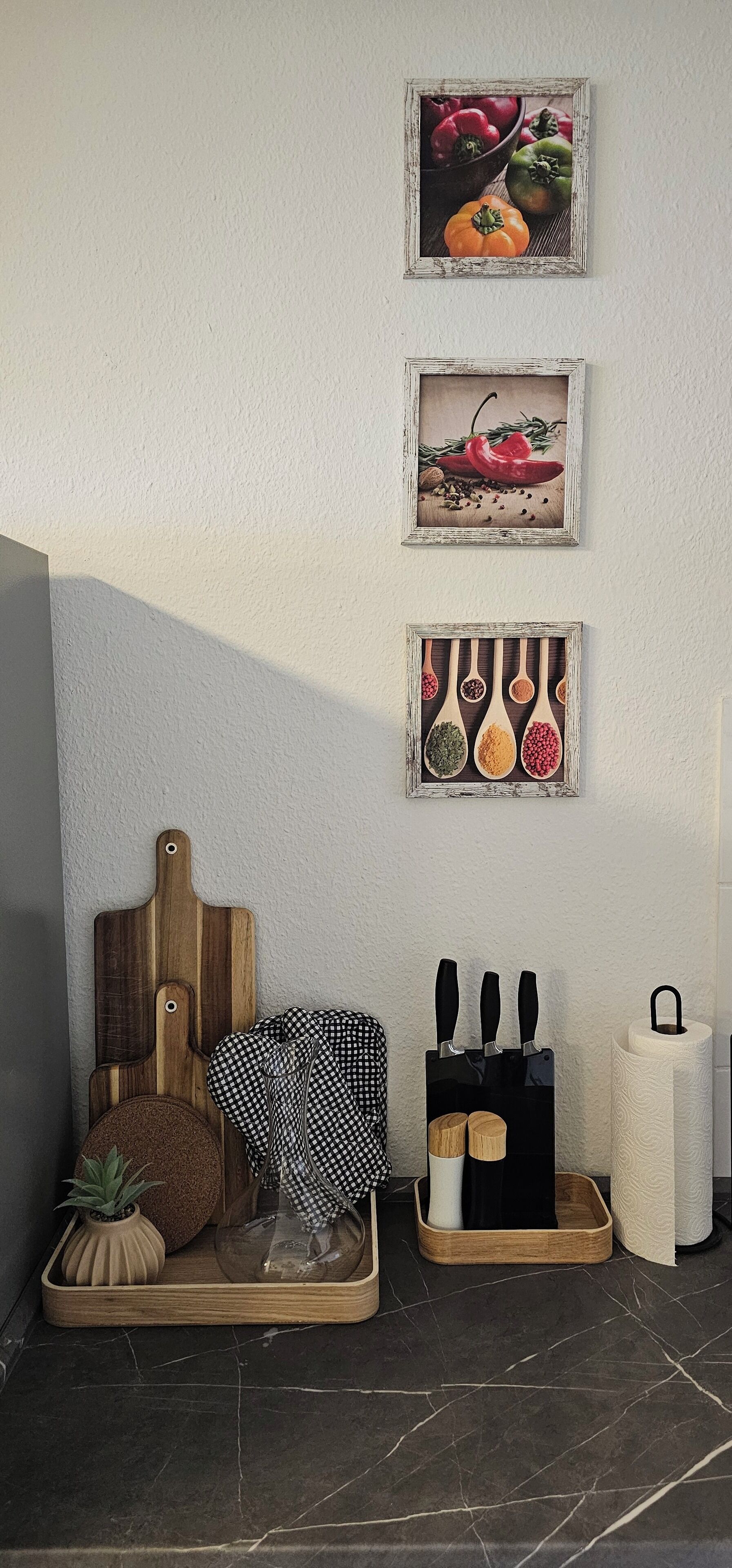 A kitchen corner with a wooden cutting board, a knife block, and a roll of paper towels.