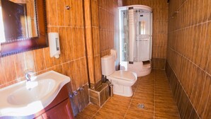 Un baño con lavamanos, inodoro y ducha.