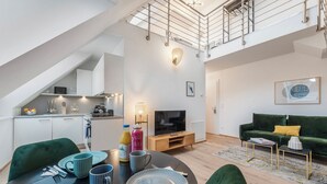 Eine moderne Wohnung mit Essbereich, Küche, Wohnzimmer und einem Schlafzimmer im oberen Bereich.