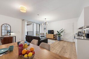Un apartamento moderno con comedor, cocina, sala de estar y balcón.