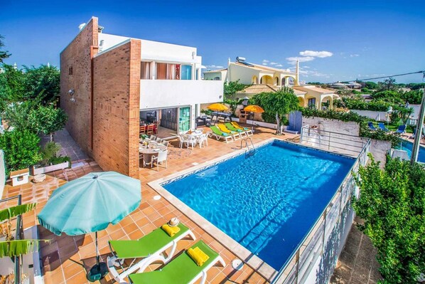 A modern hotel with a swimming pool, outdoor seating, and a view of the surrounding landscape. - Atlantic Sul in Albufeira (Albufeira)