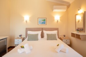 Een hotelkamer met een groot bed, twee nachtkastjes, een bureau en een spiegel.