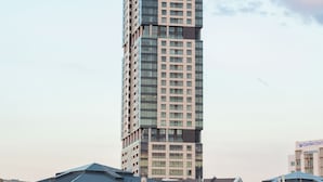 Un edificio alto y moderno con varias plantas y fachada de vidrio.