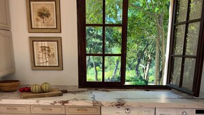 A kitchen with a large window, a washing machine, and a bowl of fruit. - 4-bedroom villa with private pétanque pool and padel court (Le Muy)