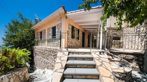 Una casa in pietra con una scala in pietra che conduce a un portico.
