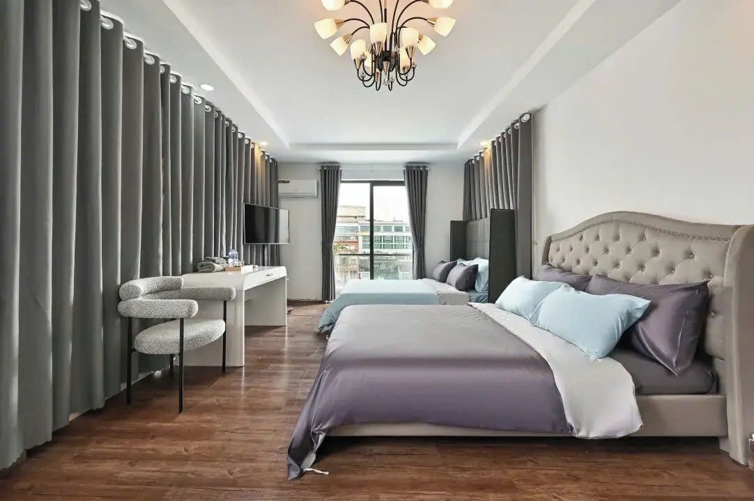 Une chambre d’hôtel moderne avec un grand lit, un bureau et une télévision.